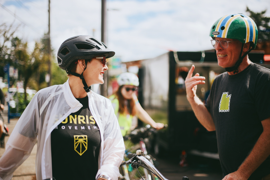 Sarah wearing a bicycling helmet talking to another cyclist